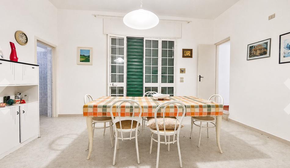 The dining room today: table with a checked cloth, bentwood chairs, white sideboard