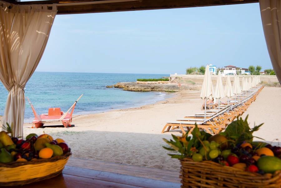 The beach club with white parasols on the rocks and turquoise water